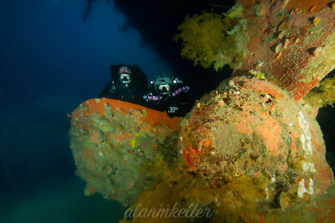 Two divers over the propeller